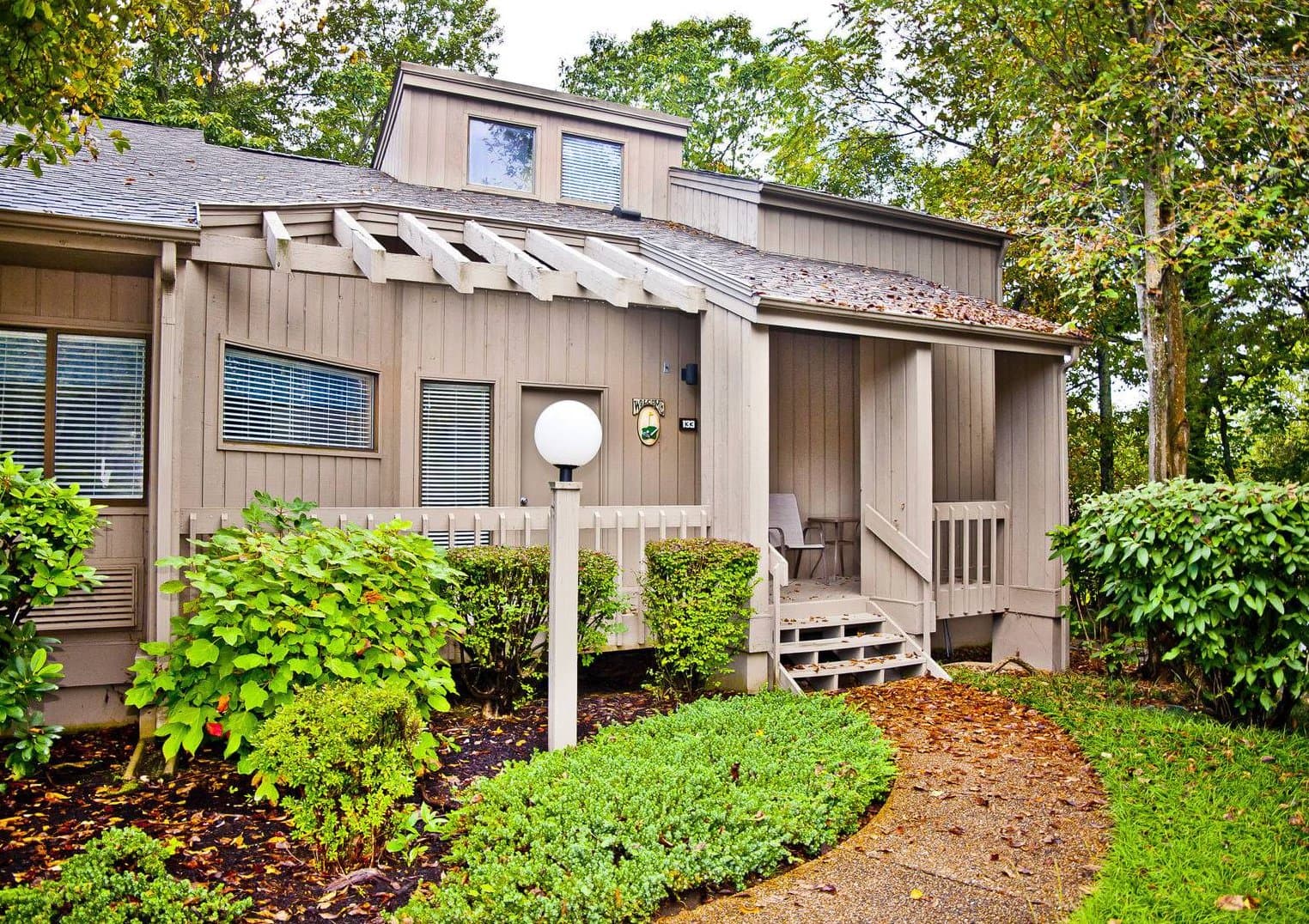 Eagle's Nest exterior with covered porch and wooded landscaping
